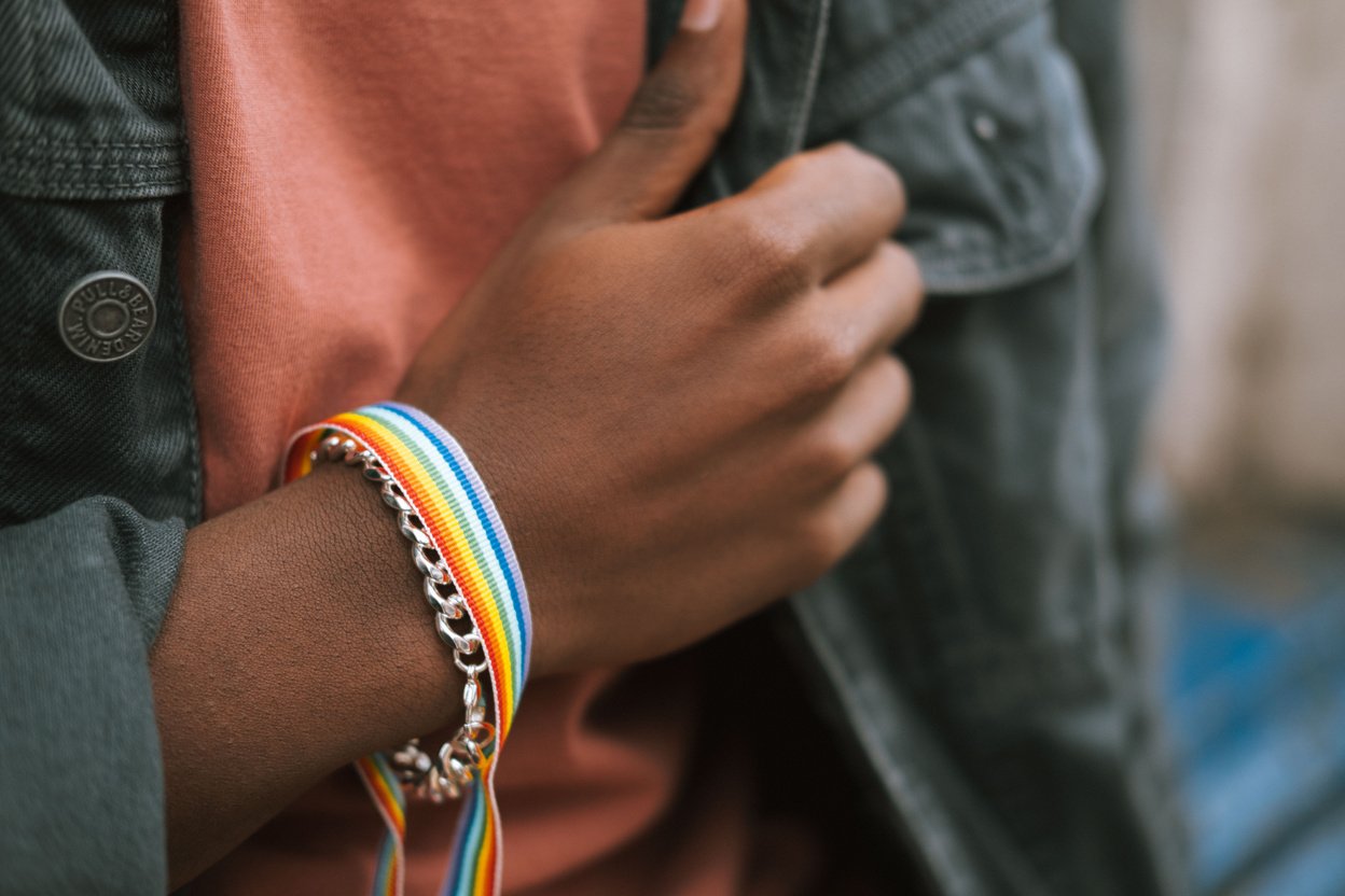 Crop black man showing bright fabric bracelet